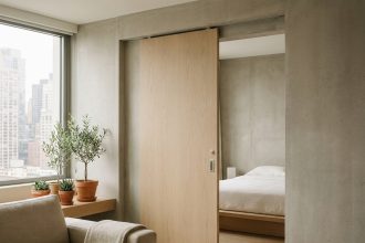 Porte coulissante en bois clair dans un petit appartement moderne avec vue sur la chambre et décoration minimaliste